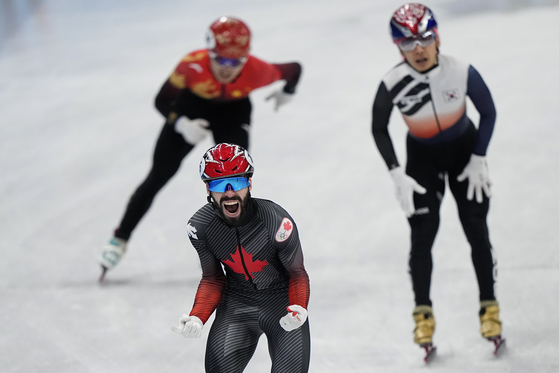 Kwak Yoon-gy, right, crosses the finish line second after Steven Dubois of team Canada in the men's 5,000-meter relay final at Capital Indoor Stadium on Wednesday. [AP/YONHAP]