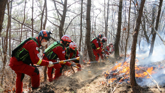 The airborne firefighting division of the National Forest Service extinguish the remaining flames at the site of the wildfire in Yeongdeok County, North Gyeongsang, 350 kilometers (217 miles) southeast of Seoul on Thursday afternoon. [YONHAP]