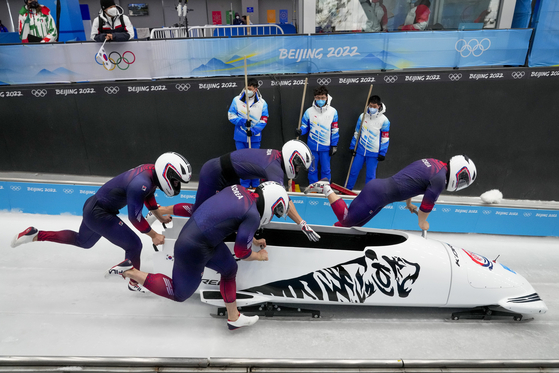 Won Yun-jong, Kim Jin-su, Jung Hyun-woo and Kim Dong-hyun start the second heat of the four-man bobsleigh event at the 2022 Winter Olympics on Saturday at Yanqing National Sliding Centre. [AP/YONHAP]