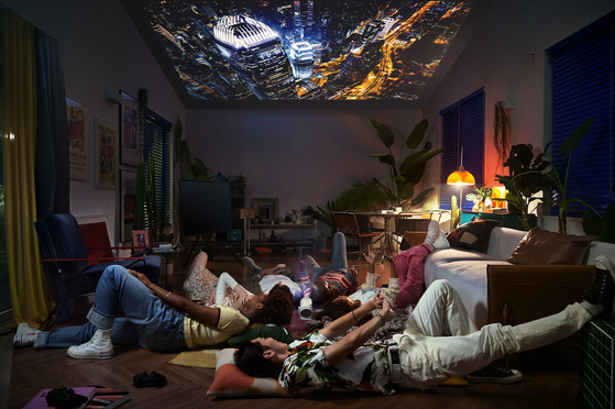 Models watch an image projected by Samsung Electronics' The Freestyle projector. [SAMSUNG ELECTRONICS]