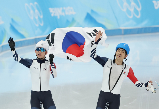 Chung Jae-won, left, and Lee Seung-hoon celebrate after medaling in the men's mass start at the 2022 Beijing Olympics on Saturday. [YONHAP]