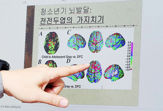 Prof. Kim Bung-nyun points to a map of adolescent brain development during an interview with the JoongAng Ilbo on Feb. 9. [WOO SANG-JO]