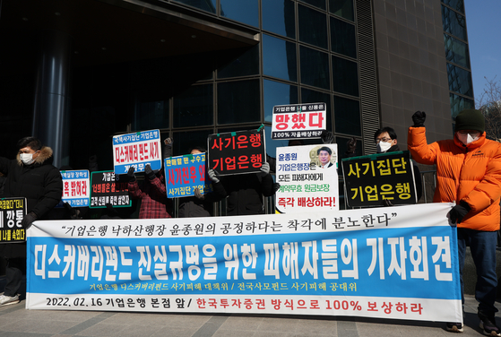 Investors of Discovery Asset Management demanding that the fund management company and the state-owned Industrial Bank of Korea refund 100 percent of their investment loss in front of the bank’s headquarters in Seoul on Wednesday. [YONHAP]
