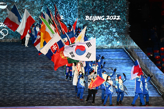 Korean flag bearer Cha Min-kyu and other flagbearers enter the stadium during the closing ceremony of the Beijing 2022 Winter Olympic Games, at the National Stadium in Beijing, on Sunday. [AFP/YONHAP]