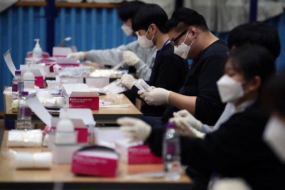 Educational staff prepare Covid-19 home testing kits at a middle school in Incheon on Monday to give to students ahead of the spring semester. [NEWS1]