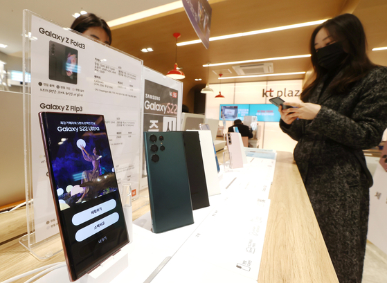 Customers check out Samsung Electronics’ flagship Galaxy S22 smartphone at KT Plaza in Jongno, central Seoul, on Tuesday. People that made pre-orders received their phone on Tuesday. The official release is Feb. 25. [YONHAP]