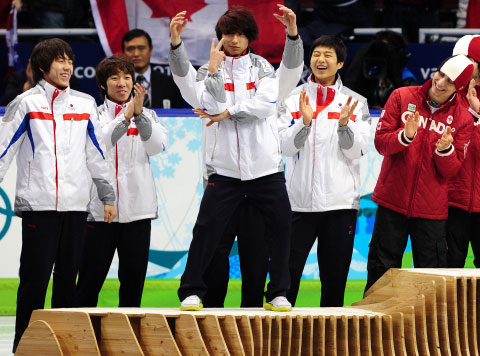 Kwak Yoon-gy, center, dances on the podium at the 2010 Vancouver Games after winning the men's 5,000-meter relay silver medal. [SBS/JOONGANG ILBO]