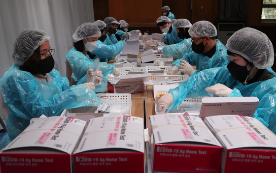Staff at the Busan Nambu Office of Education in Busan sort Covid-19 home test kits to be distributed to schools ahead of the new semester Wednesday. Over 3.62 million test kits will be distributed for free to students and faculty in Busan through March amid the Omicron surge. [SONG BONG-GEUN]