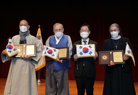 Ven. Seollae, far left, Wesley John Wentworth Jr., second from left, and Sister Cristina Evelina Gal, far right, are awarded Korean citizenship by Justice Minister Park Beom-gye in a ceremony Thursday. [YONHAP] 