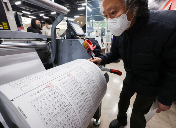 A worker checks ballots for the upcoming March 9 presidential election at a printing house in Seocho Ward in southern Seoul on Tuesday. [YONHAP]