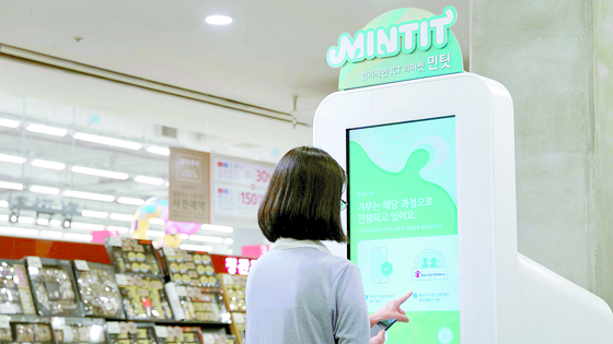 A customer uses Mintit's smartphone collecting machine. SK Networks' wholly-owned subsidiary Mintit accounted for 10 percent of the total transactions, or 100 billion units, in 2021, the company announced. [MINTIT]