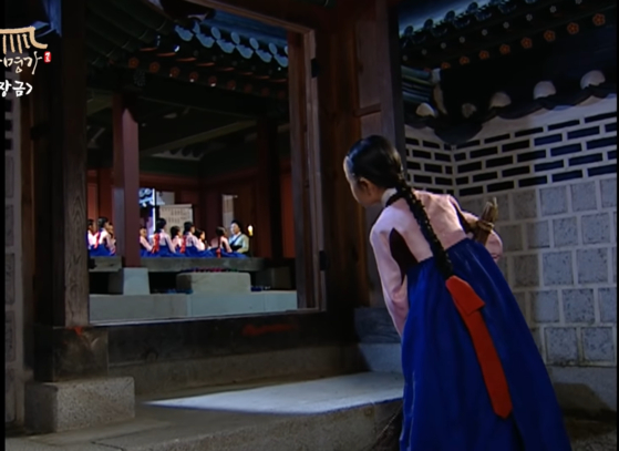 여기서 소녀의 머리띠 끝에 묶은 빨간 리본은 MBC 사극 드라마 《대장금》(2003~2004)에 등장하는 댕기의 한 예이다. [SCREEN CAPTURE]