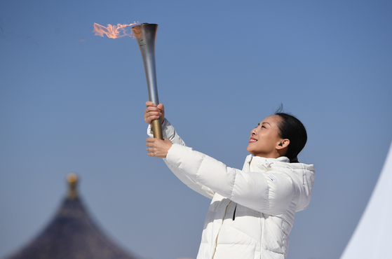 Tai Lihua, head of the China Disabled People's Performing Art Troupe, holds the torch during the Beijing 2022 Paralympic Torch Relay and Flame Lighting Ceremony at the Temple of Heaven park in Beijing, on Wednesday. [XINHUA/YONHAP]