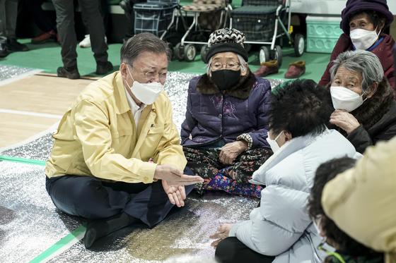 President Moon Jae-in, left, visits a temporary shelter at a sports center in Uljin County, North Gyeongsang, Sunday, after major wildfires in Korea’s east coast, offering words of support to the displaced victims. [BLUE HOUSE] 