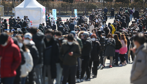 People wait to get tested for Covid-19 at a screening center at the Jamsil Sports Complex in southern Seoul on Sunday. [NEWS1]