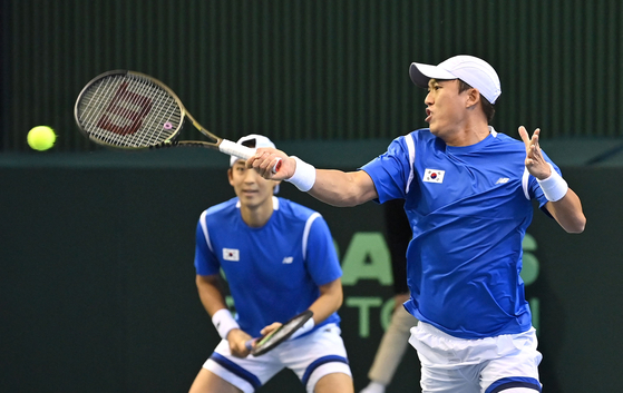 Nam Ji-sung, right, hits a return while playing with Song Min-kyu against Austria's Alexander Erler and Lucas Miedler during the Davis Cup qualifiers in southern Seoul on March 5. [AFP/YONHAP]