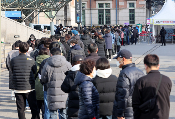 People wait to get tested for Covid-19 at a screening center near Seoul Station in central Seoul on Monday. [NEWS1]
