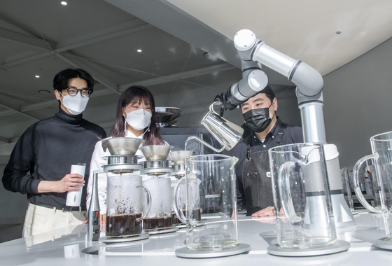A robot arm pours hot water to make drip coffee at the coffee shop Lounge'X in Everland, an amusement park in Yongin, Gyeonggi. Lounge'X, a cafe jointly launched by tech start-up Lounge'Lab and Everland, opened Monday. [YONHAP]