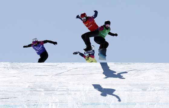 Lee Je-hyuk of Korea, left, competes in the men's para snowboard cross SB-LL2 quarterfinals at Genting Snow Park in Zhangjiakou, China on Monday. [REUTERS/YONHAP]