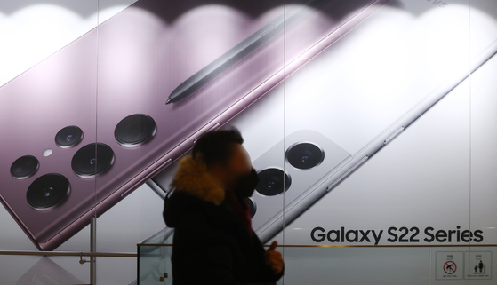 A pedestrian passes by a poster of Samsung Electronics' Galaxy S22 smartphone in southern Seoul on Feb. 14. The company said on Monday that it is assessing the current situation after being hacked by Lapsus$. [YONHAP]