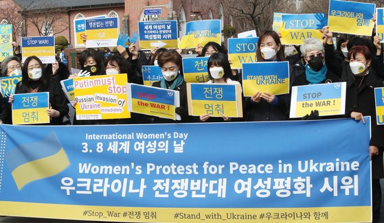 In commemoration of International Women’s Day on March 8, members of civic groups advocating women’s rights stage an anti-war rally in front of the Russian Embassy in central Seoul on Tuesday to denounce Russia’s invasion of Ukraine. [NEWS1]