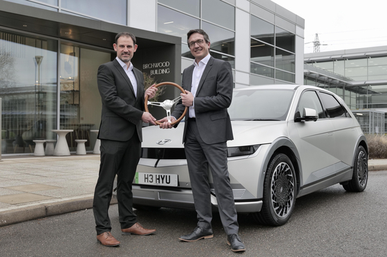 John Challen, left, editor and managing director of the UK Car of the Year Awards, and Ashley Andrew, managing Director of Hyundai Motor UK, pose for a photo after the Ioniq 5 was named UK Car of the Year 2022.. [HYUNDAI MOTOR]