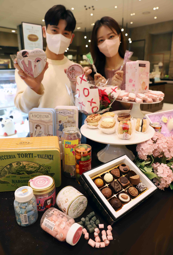Models hold up sweets at the Shinsegae Department Store Gangnam branch in southern Seoul on Wednesday. The department store's Gangnam branch will carry products from 20 candy and chocolate brands including Candy Me and Drops until White Day on March 14. It is celebrated as a counterpart to Valentine's Day in Korea. [SHINSEGAE DEPARTMENT STORE]