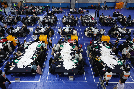 Election staffers tally the votes at a counting station in the Mapo-Gu Min Sports Center in Mapo Distict, western Seoul, Wednesday night after voting in the presidential election closed at 7:30 p.m. [YONHAP]