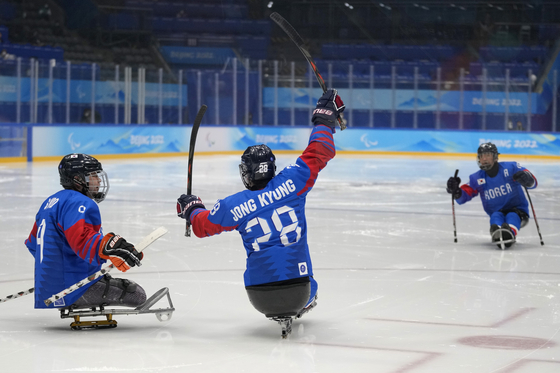 Korea's Lee Jong-kyung celebrates with teammate Choi Si-woo after scoring a goal against Italy during a para ice hockey qualifying final match at the 2022 Winter Paralympics in Beijing on Wednesday. [AP/YONHAP]