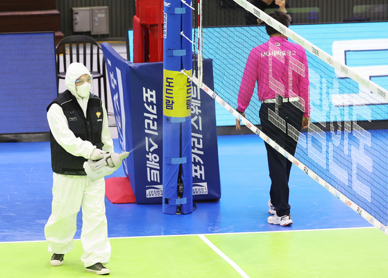 A health official disinfects Suwon Gymnasium in Suwon on Feb. 22 after a match between Suwon Hyundai Engineering & Construction Hillstate and the Industrial Bank of Korea Altos. [YONHAP]