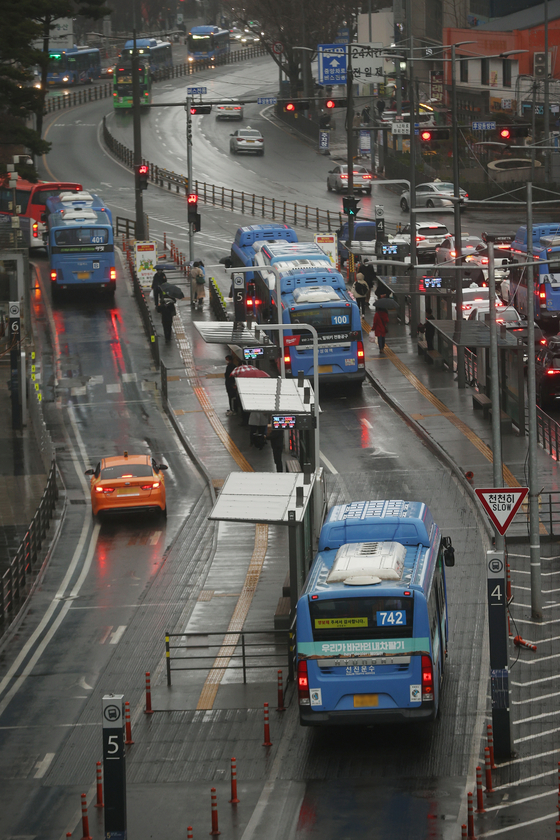 Buses traveling near Seoul Station in Seoul on Monday. On Monday, the government started accepting applications from bus drivers for special financial aid. The applicants will be receiving 1 million won maximum if they prove that their incomes have been affected by Covid-19. Drivers on non-public buses that run on routes and those driving chartered buses can apply if they were driving before Jan. 3. An estimated 86,300 will apply, according to the Ministry of Land, Infrastructure and Transport. [YONHAP]