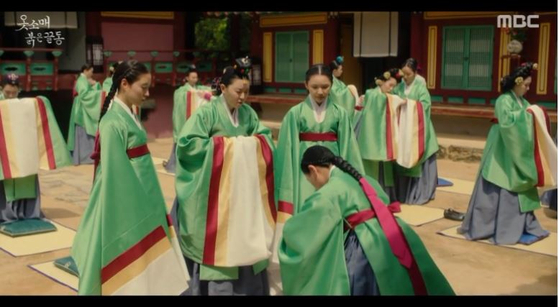 Saengaksi, or junior court ladies, hold a ceremony to be promoted to nain, assistant court ladies, 15 years after entering the palace. In the drama, however, the junior court ladies all become nain after turning 18, including Deok-im. [MBC] 