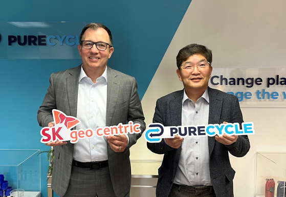 Na Kyung-soo, president and CEO of SK Geo Centric, right, poses for photo with Mike Otworth, CEO of PureCycle, after signing a deal to acquire a stake worth $55 million in the U.S. plastic recycling company on Tuesday. [SK GEO CENTRIC]