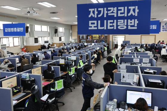 Staff at the Gwangjin District Emergency Management Agency in eastern Seoul monitor Covid-19 patients on Wednesday. Starting on that day, Covid-19 patients in their 50s with underlying diseases were excluded from intensive care groups and have to receive at-home treatment. [YONHAP]