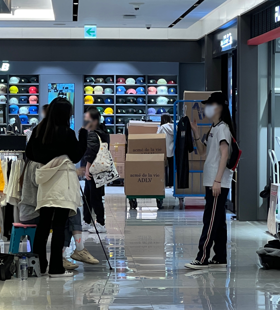 A group of Chinese sellers live stream in front of the MLB store at the Shinsegae Duty Free branch in central Seoul. [LEE TAE-HEE] 
