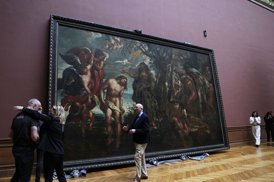 A chief technician, left, is congratulated after successfully moving the 'Baptism of Christ', by Baroque painter Peter Paul Rubens inside a gallery at the Royal Museum of Fine Arts Antwerp in Antwerp, Belgium, on March 15. Moving a masterpiece is never easy, even more-so when it measures 4.11 by 6.75 meters (13.5 feet by 22.1 feet) and weighs 560 kilograms (1,225 pounds). The Rubens painting is the first to be moved back into its gallery hall after a decade long renovation of the museum which will open in September. [AP/YONHAP]