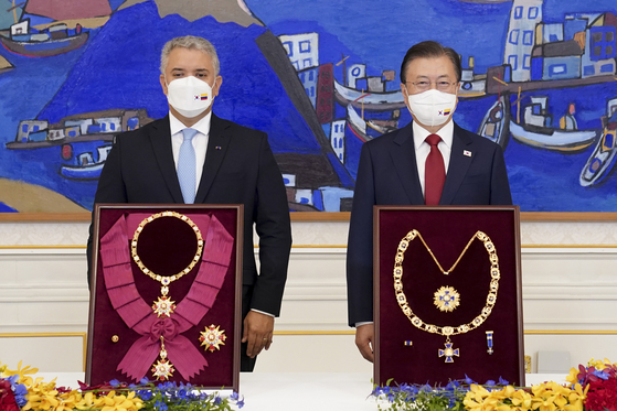 Colombian President Iván Duque Márquez, left, and Korean President Moon Jae-in, right, exchange medals during their summit in Seoul on Aug. 25, 2021. [JOINT PRESS CORPS] 