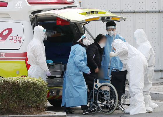 Medical staff transfer a patient at Seoul Medical Center in Jungnang District, eastern Seoul on Monday. To free up intensive care beds, from Monday, the government made Covid-19 patients whose symptoms have improved move out of I.C.U.s earlier. [NEWS1]