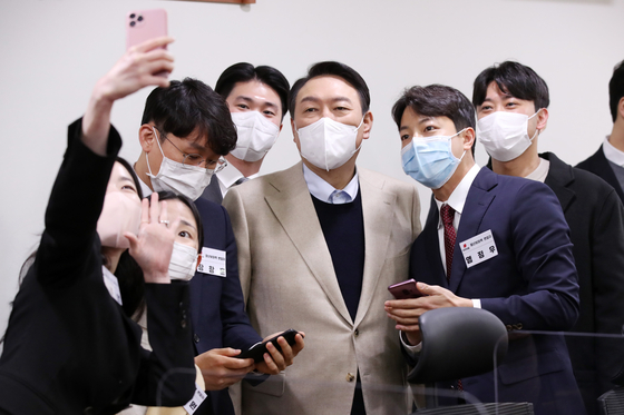 The main opposition People Power Party's presidential candidate Yoon Suk-yeol poses for a photograph with applicants to his campaign's youth outreach posts on Dec. 18. [YONHAP]