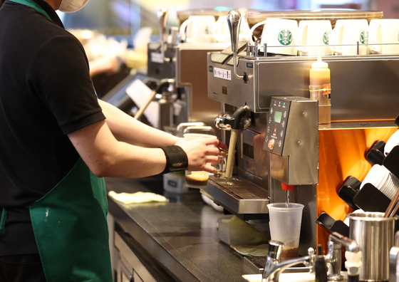 A barista makes a cup of coffee at a Starbucks in Seoul on Monday. According to the Korea Customs Service, Korea imported $916.5-million worth of coffee — including beans and other coffee products — last year, up 24.2 percent on year. [YONHAP]
