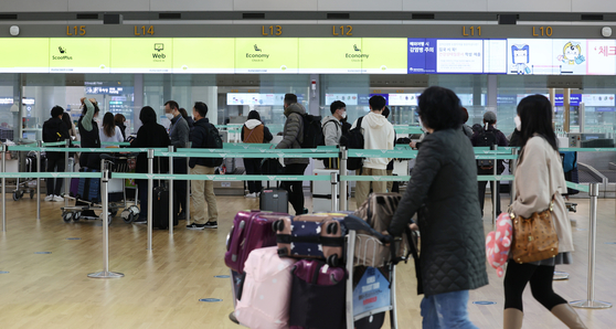 Travelers line up to check into flights at Incheon International Airport on Monday. A new rule exempting vaccinated inbound travelers from a seven-day quarantine went into effect the same day. [YONHAP]