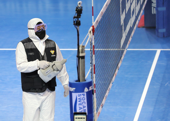 A health official disinfects Hwaseong Indoor Arena in Hwaseong, Gyeonggi on Sunday during a match between Korea Ginseng Corporation and the Industrial Bank of Korea Altos. [NEWS1]