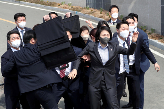 Bodyguards surround former President Park Geun-hye after a soju bottle was thrown at her while she was speaking to supporters and the media outside her residence in Dalseong-gun, Daegu, soon after her release from the hospital on Thursday morning. [YONHAP]