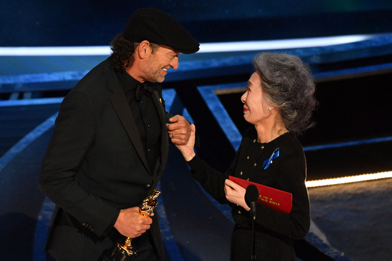 American actor Troy Kotsur, left, accepts the Oscar for Best Supporting Actor from Korean actor Youn Yuh-jung during the 94th Academy Awards ceremony on March 27. [AFP/YONHAP]