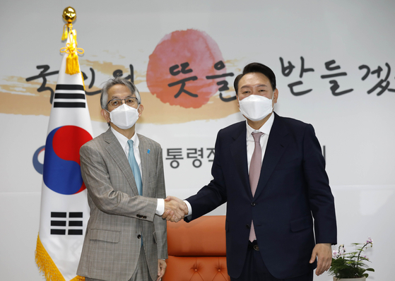 President-elect Yoon Suk-yeol, right, shakes hands with Japanese Ambassador to Korea Koichi Aiboshi ahead of their meeting at the transition office in Tongui-dong, central Seoul, Monday. [JOINT PRESS CORPS]