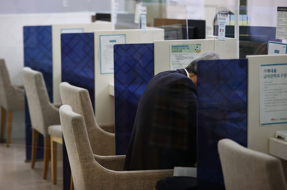 A customer gets advice about loans at a commercial bank in Seoul in October. [YONHAP]