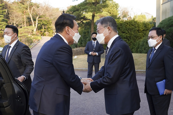 President Moon Jae-in, right, and President-elect Yoon Suk-yeol shake hands as they meet before their first dinner meeting at the Blue House in central Seoul Monday. [JOINT PRESS CORPS]