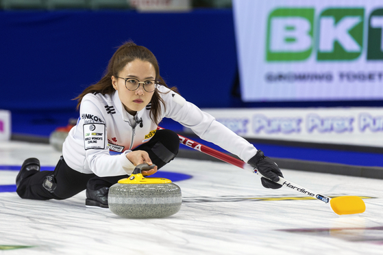 Korea skip Kim Eun-jung slides a stone against Switzerland in the gold medal game during the World Women's Curling Championship in Prince George, British Columbia on Sunday. [AP/YONHAP]