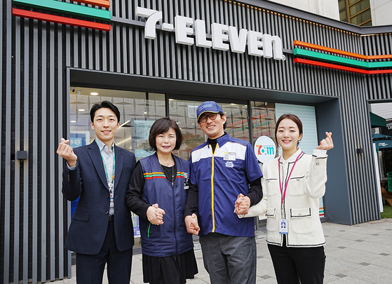 Franchisees of Ministop and 7-Eleven pose together in front of a 7-Eleven store. [7-ELEVEN]