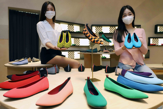 Models hold up local eco-friendly shoemaker Nodo's shoes made with recycled fabric from plastic bottles at Shinsegae Department Store's Gangnam branch in southern Seoul. Shinsegae Department Store announced Wednesday that it will carry Nodo's products until April 4 at its Gangnam branch. [YONHAP]